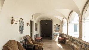 A corridor with arched ceilings, a bench, and a wall with decorative paintings. - Hotel Casa Palmela (Setubal)