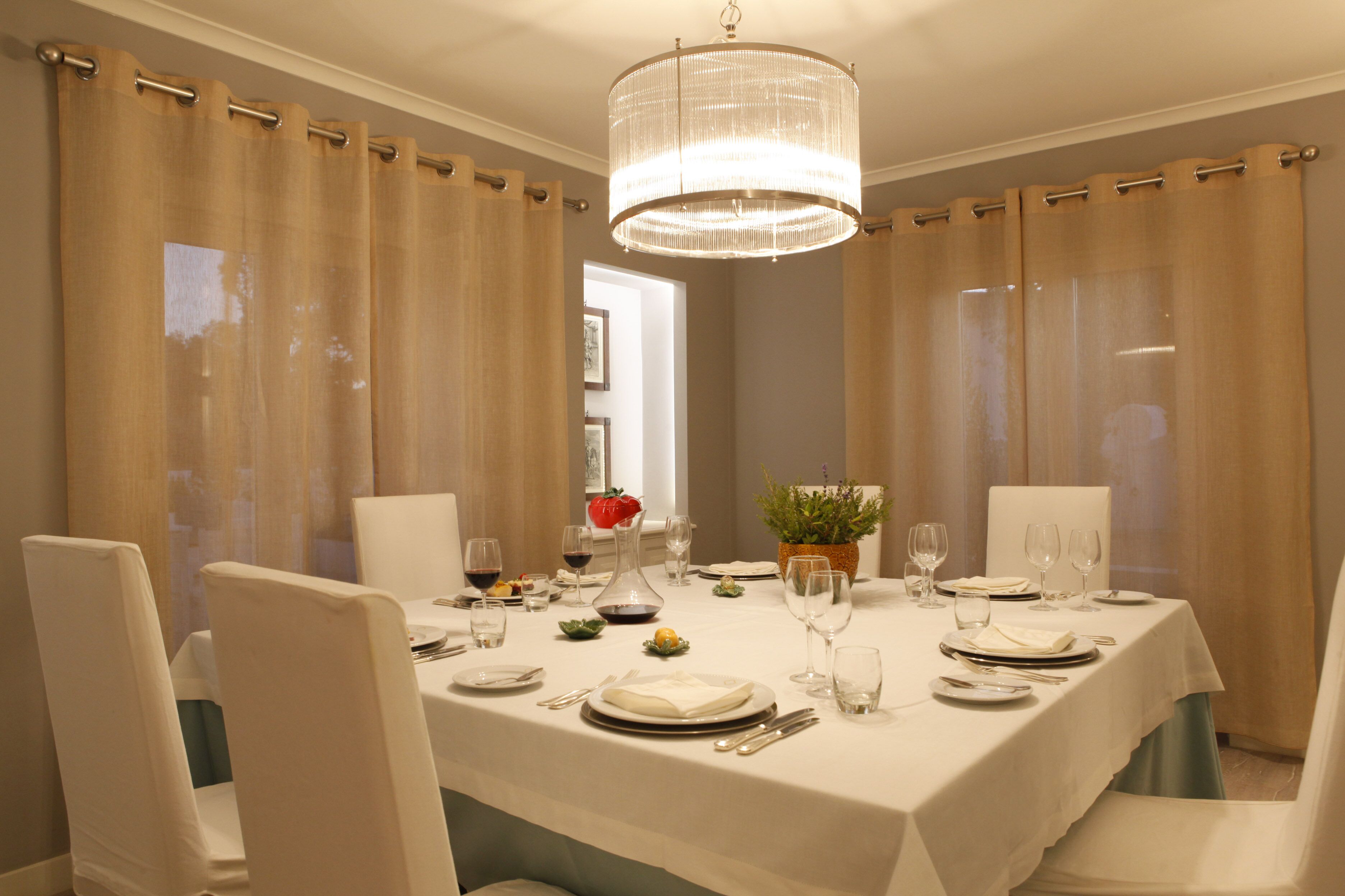 A dining room with a table set for four, including plates, glasses, and cutlery.