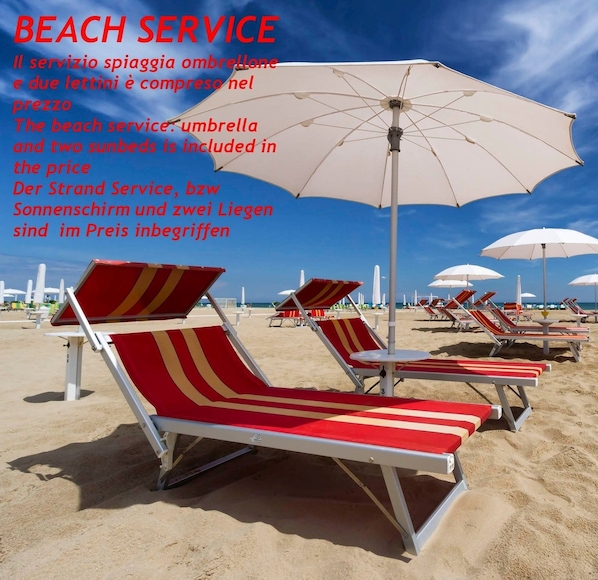 In Strandnähe, weißer Sandstrand, Liegestühle, Sonnenschirme