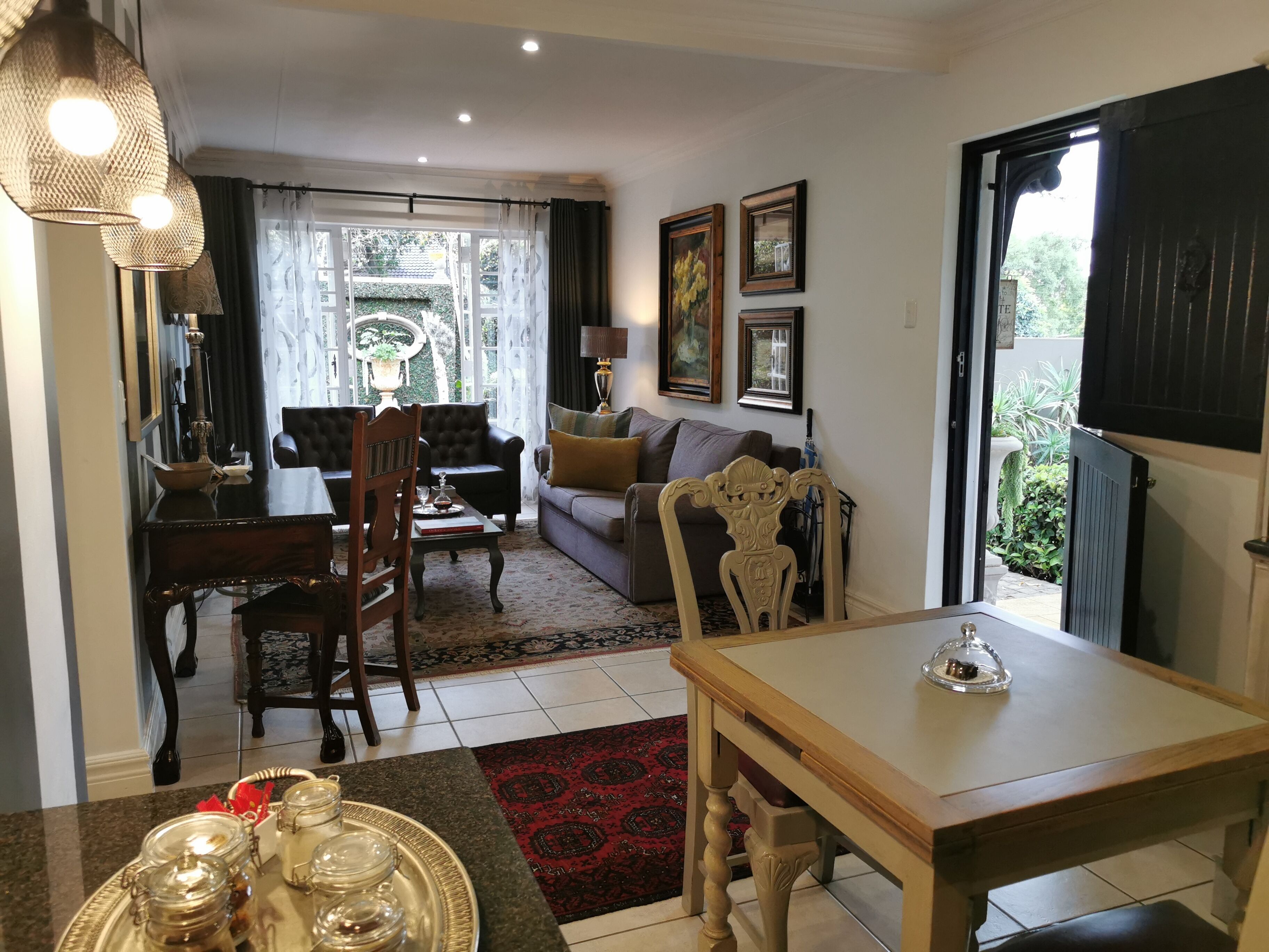 Sala de estar con comedor, que incluye un sofá, sillas, una mesa y vistas al exterior.