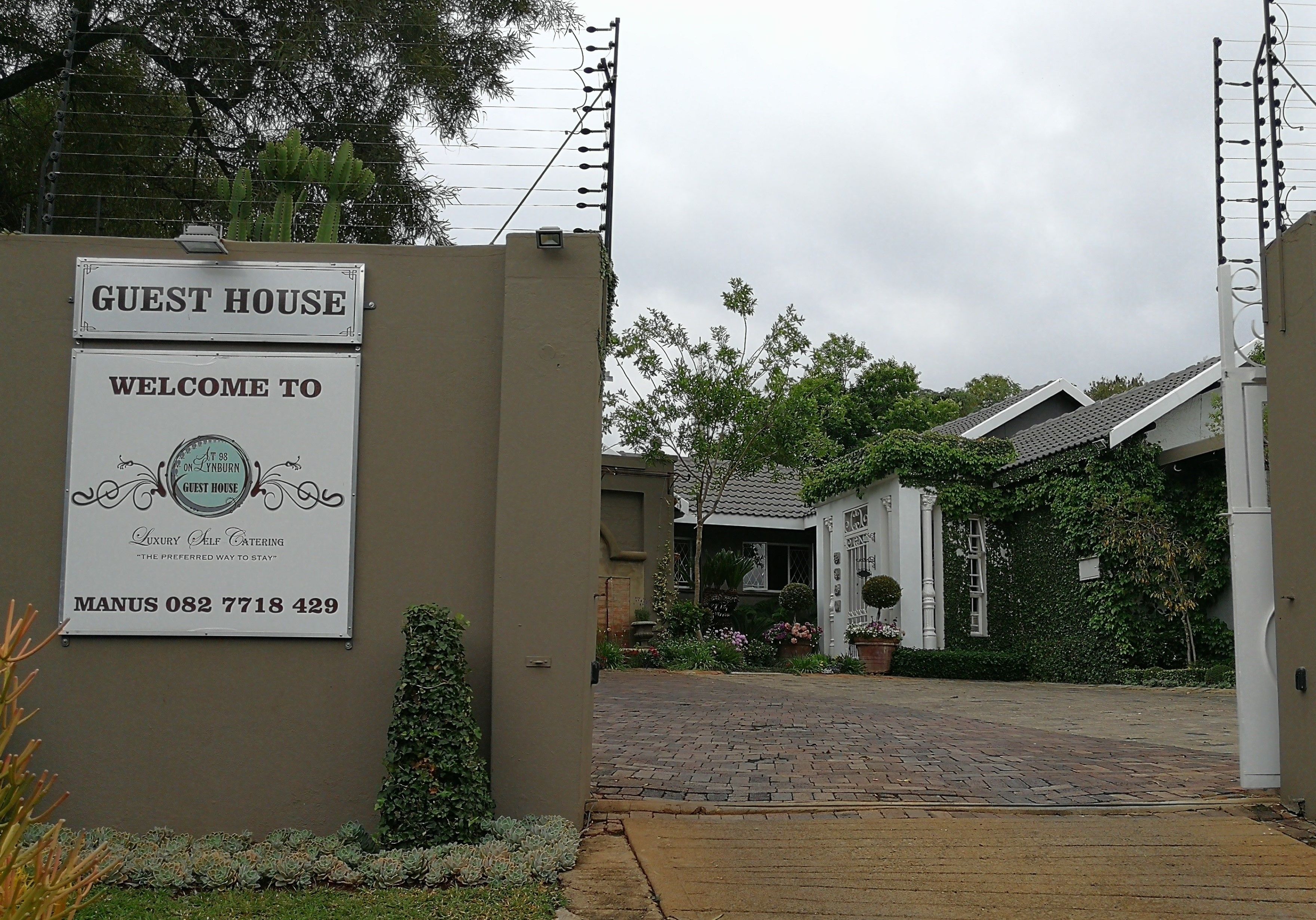 A guest house sign with a contact number.