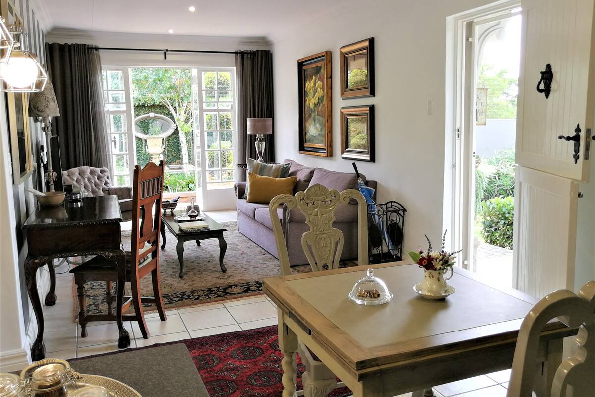A well-lit living room with a dining area, a sofa, a coffee table, and a chandelier.