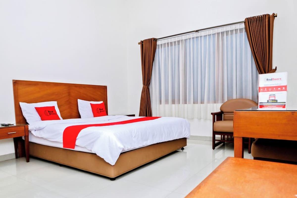 Una habitación de hotel con una cama, un escritorio y una silla.