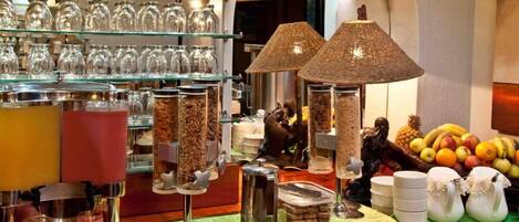A buffet area with various food items, a coffee station, and a selection of glassware on shelves.