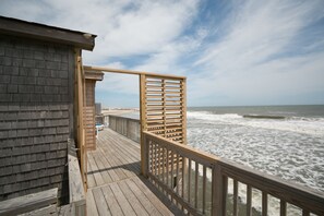 A wooden deck with a railing overlooking the ocean. - Outer Banks Motel (Buxton)