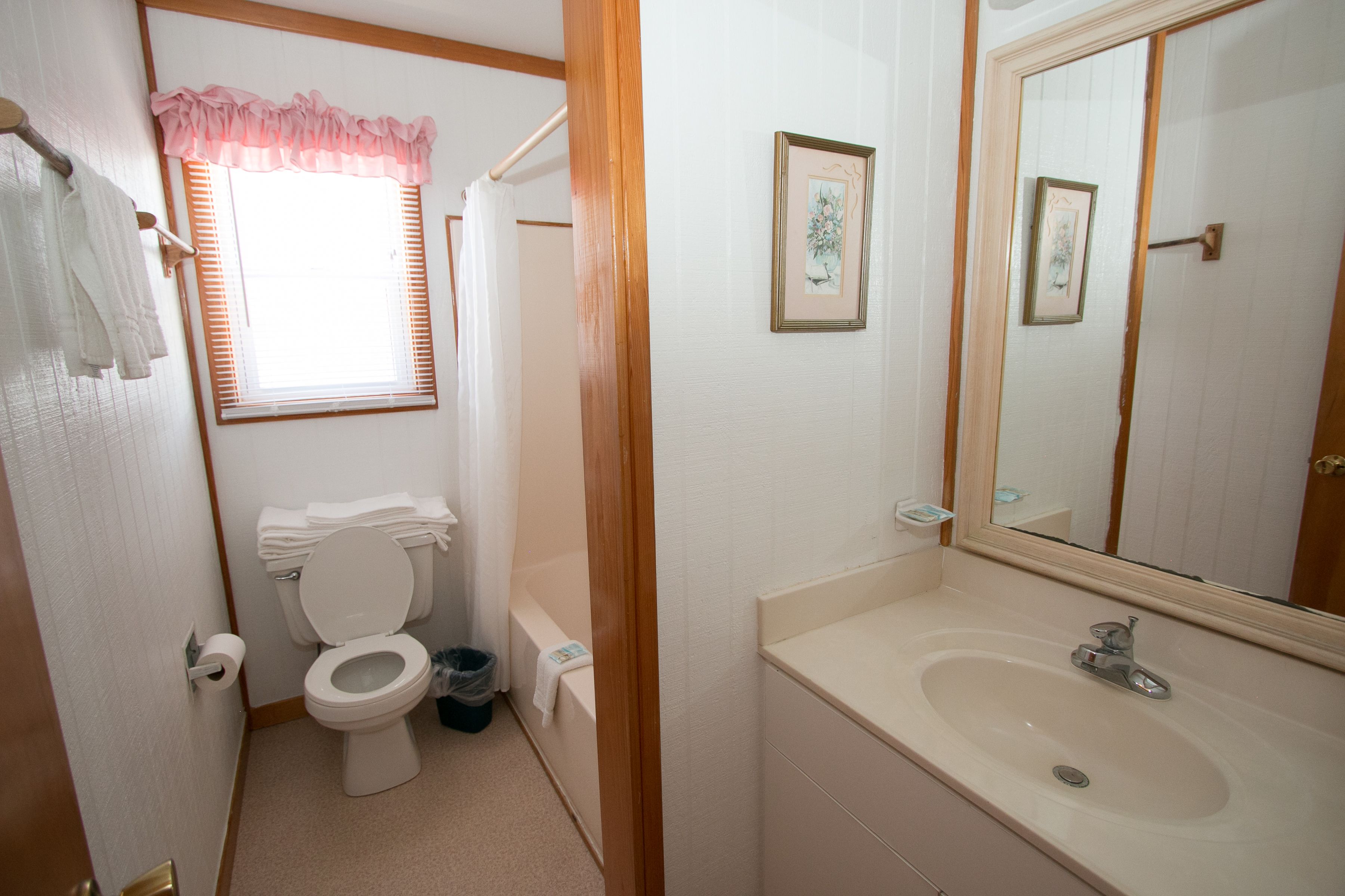 A bathroom with a toilet, sink, and shower.
