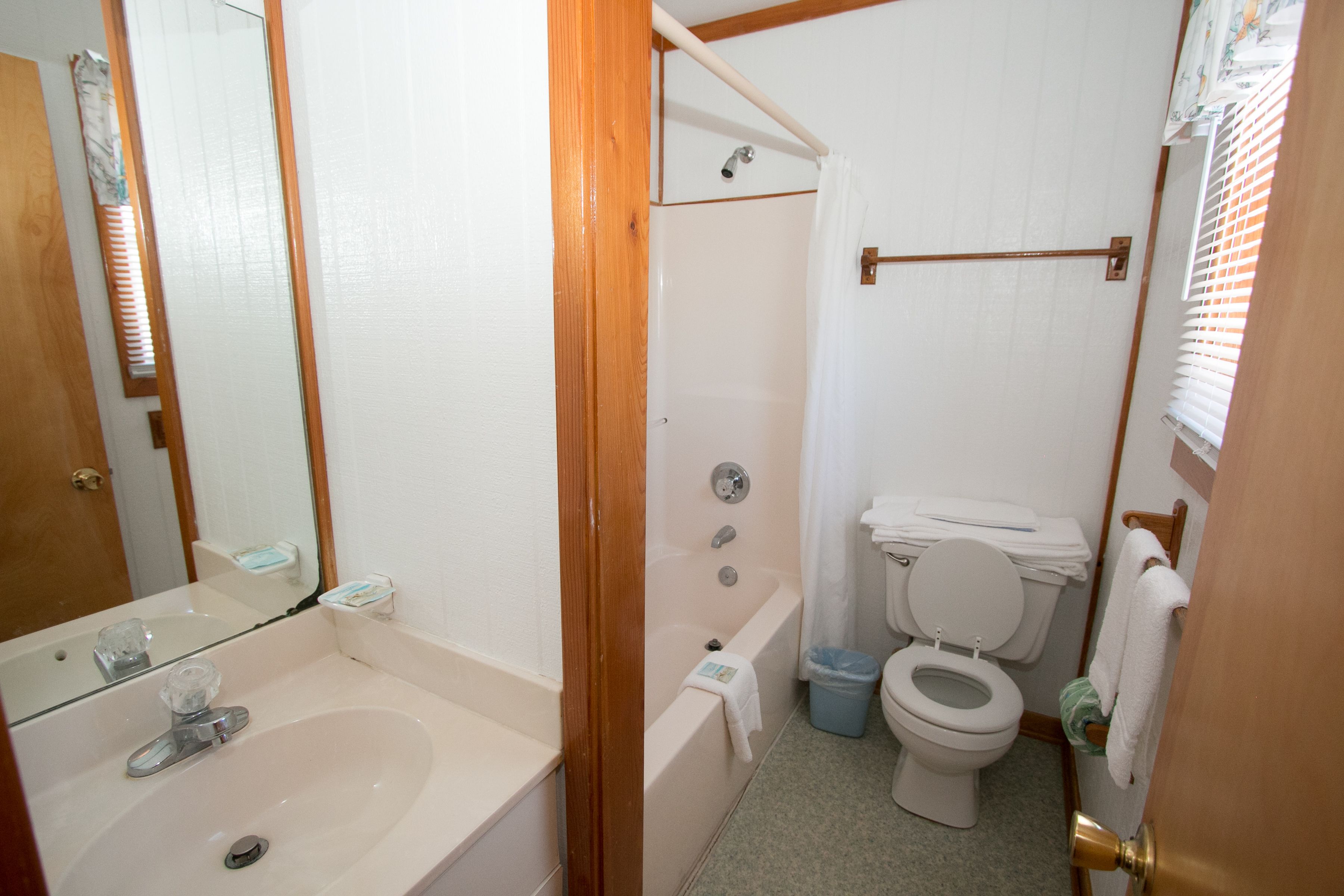 A bathroom with a sink, toilet, bathtub, and a shower curtain.