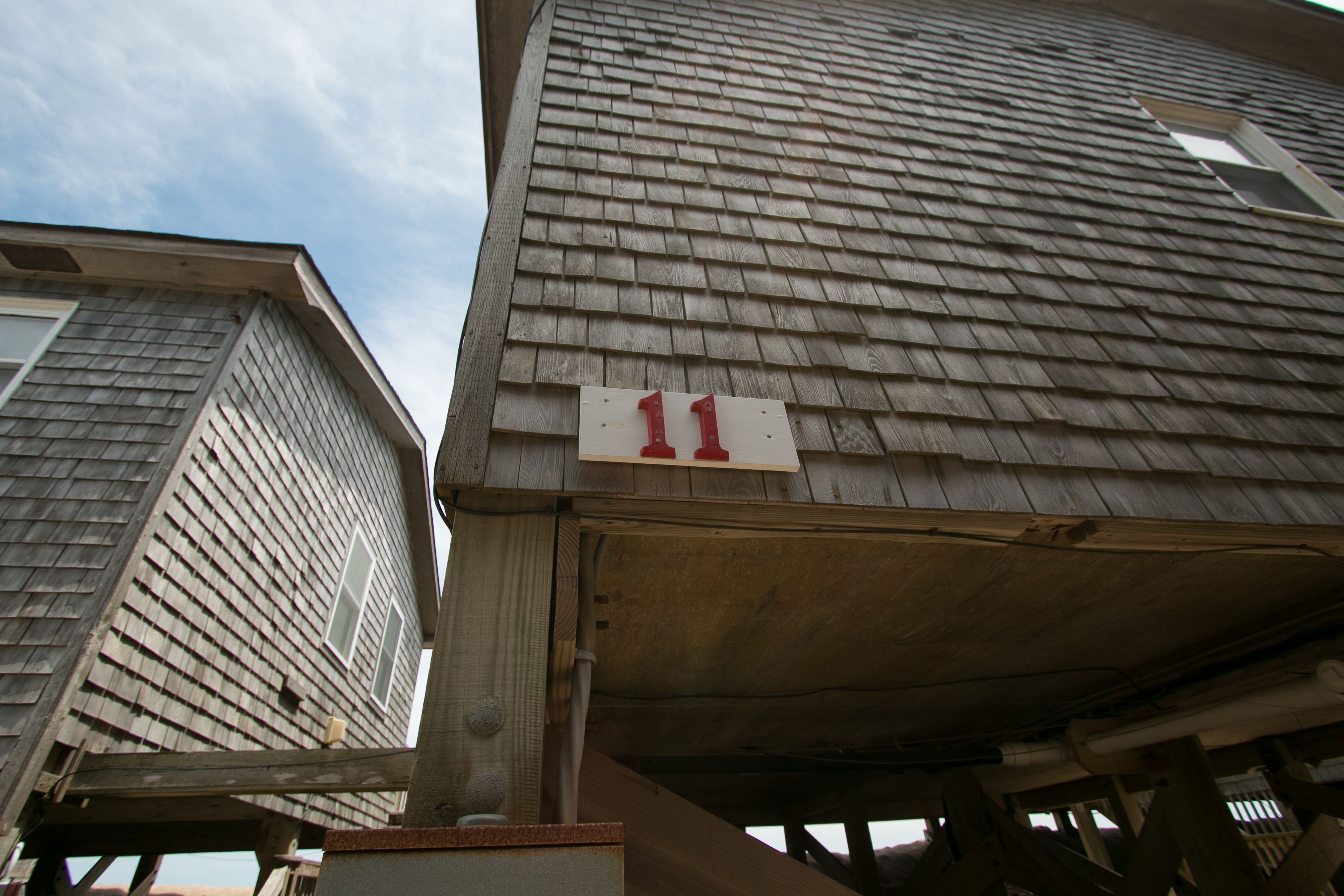 Ein Gebäude mit einer Holzschindel-Fassade und einem sichtbaren Schild mit der Nummer 11.