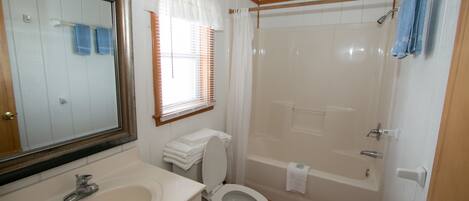 A bathroom with a sink, toilet, and bathtub.