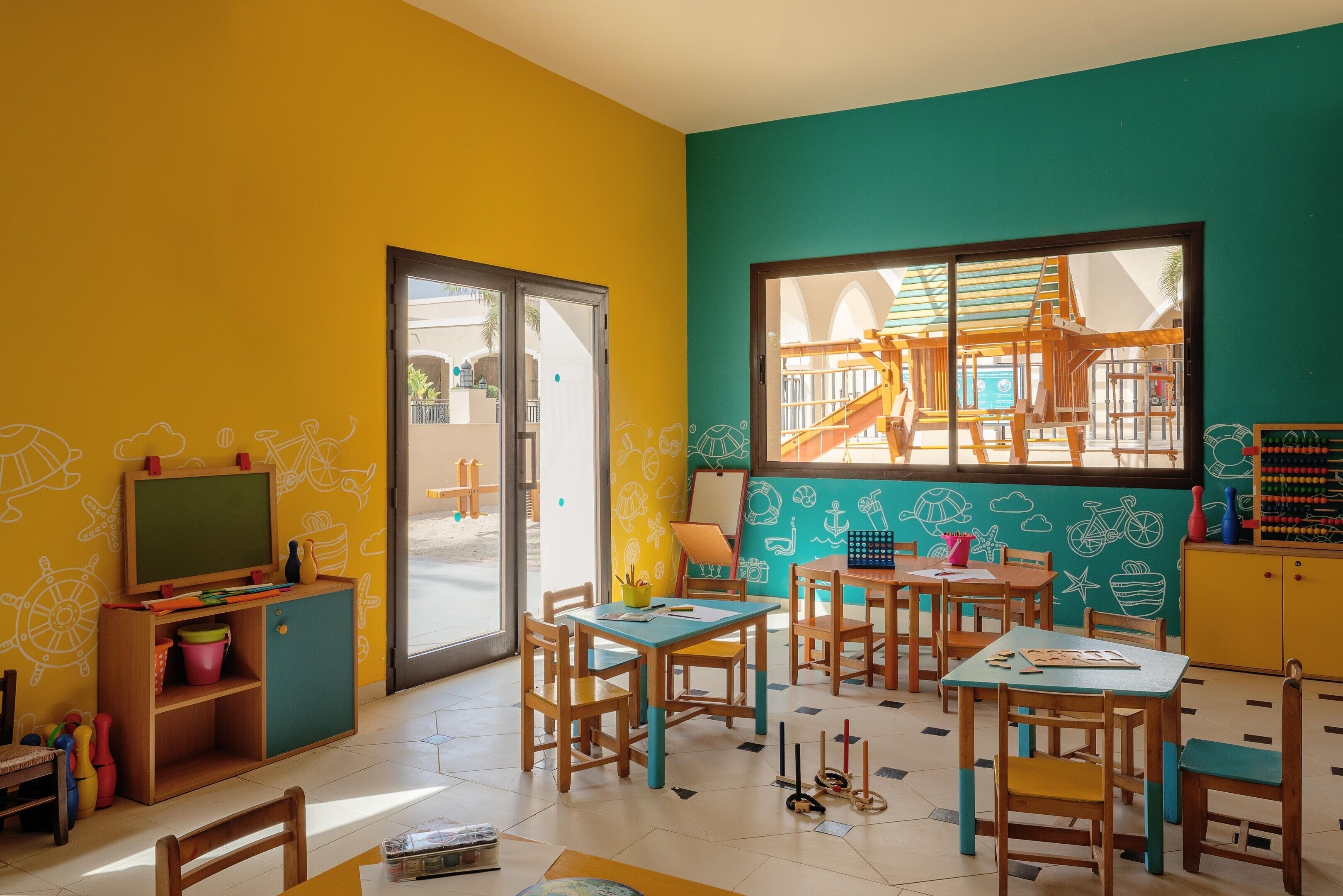 A classroom with wooden furniture, a chalkboard, and educational toys.
