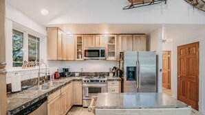A modern kitchen with wooden cabinets, stainless steel appliances, and a large island. - 01sl - Hot Tub - Pet Friendly - Bbq - Sleeps 8 3 Bedroom Home by RedAwning (Deming)