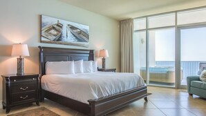 Ein Hotelzimmer mit einem großen Bett, zwei Nachttischen mit Lampen, einem Gemälde über dem Bett und Blick durch ein großes Fenster.
