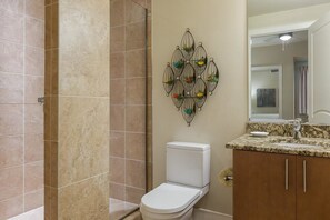 Une salle de bain comprenant des toilettes, un lavabo et un espace douche.