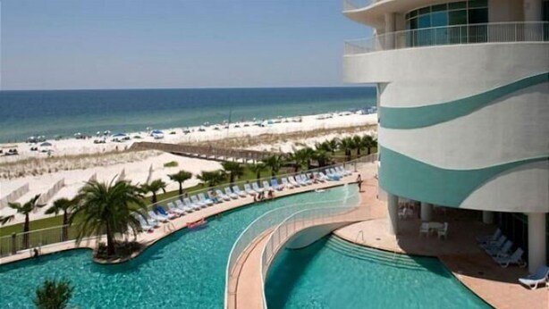 Ein Resort mit Bogenpool, Blick auf den Strand und einem modernen Gebäude mit gewölbtem Fassadengestalt.