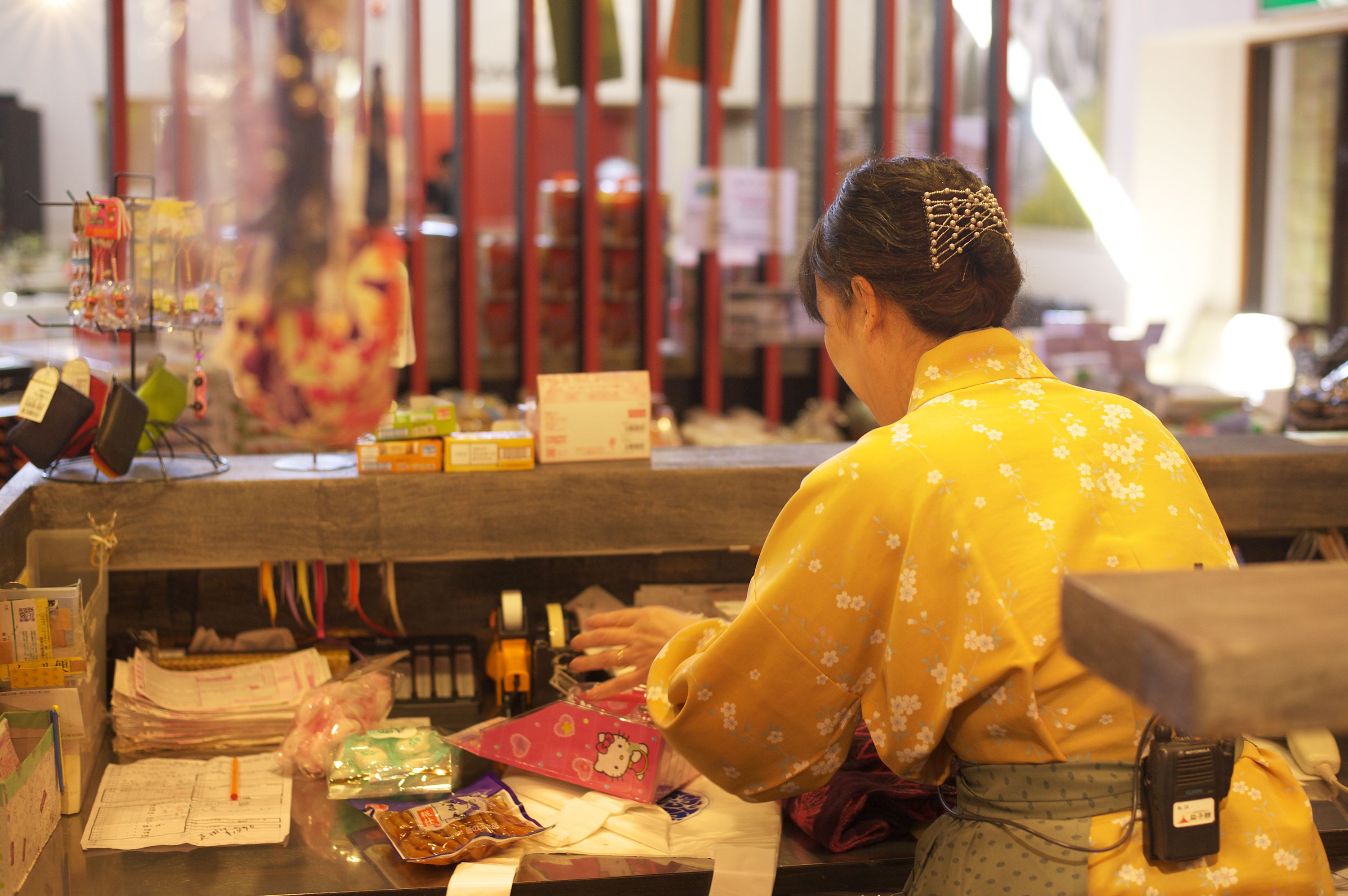 A person working at a counter with various items and papers.