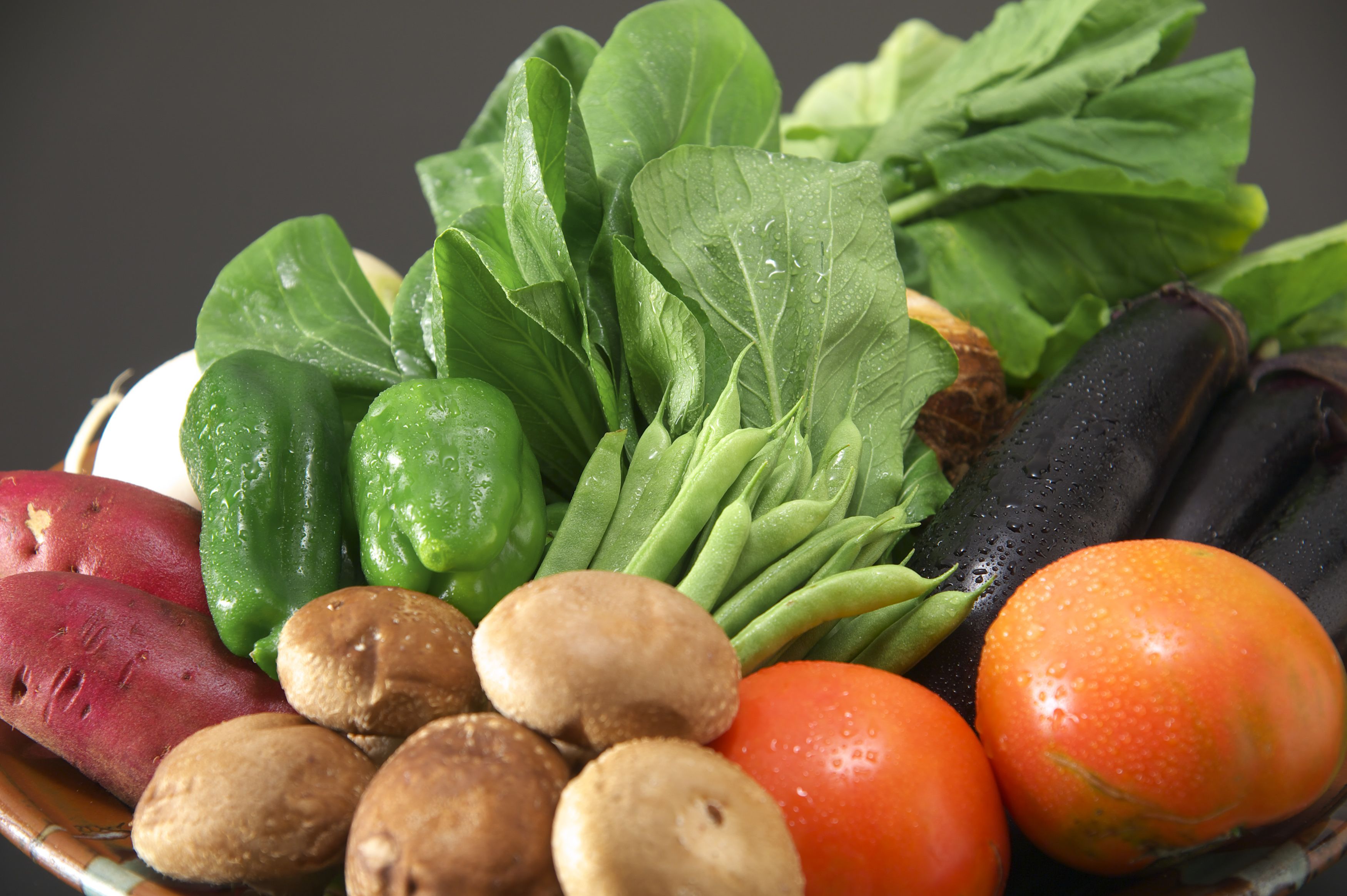 A variety of fresh vegetables including spinach, tomatoes, and mushrooms.