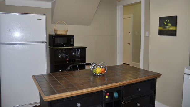 A kitchen with a refrigerator, microwave, and a wooden countertop. - Moncton Suites - 81 Maple Street (Moncton)