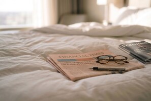 Ein Bett mit einer Zeitung, einer Brille und einem Stift.