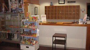 Un área de recepción con mostrador, una pequeña silla de madera y una exhibición de bocadillos.