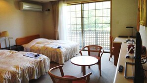 Una habitación de hotel con dos camas, un escritorio, una silla y un televisor.