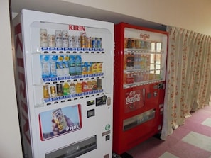 Two vending machines, one labeled 'KIRIN' and the other 'Coca-Cola', with various beverages and snacks inside. - Hotel Kosaka Gold Palace (Kosaka)