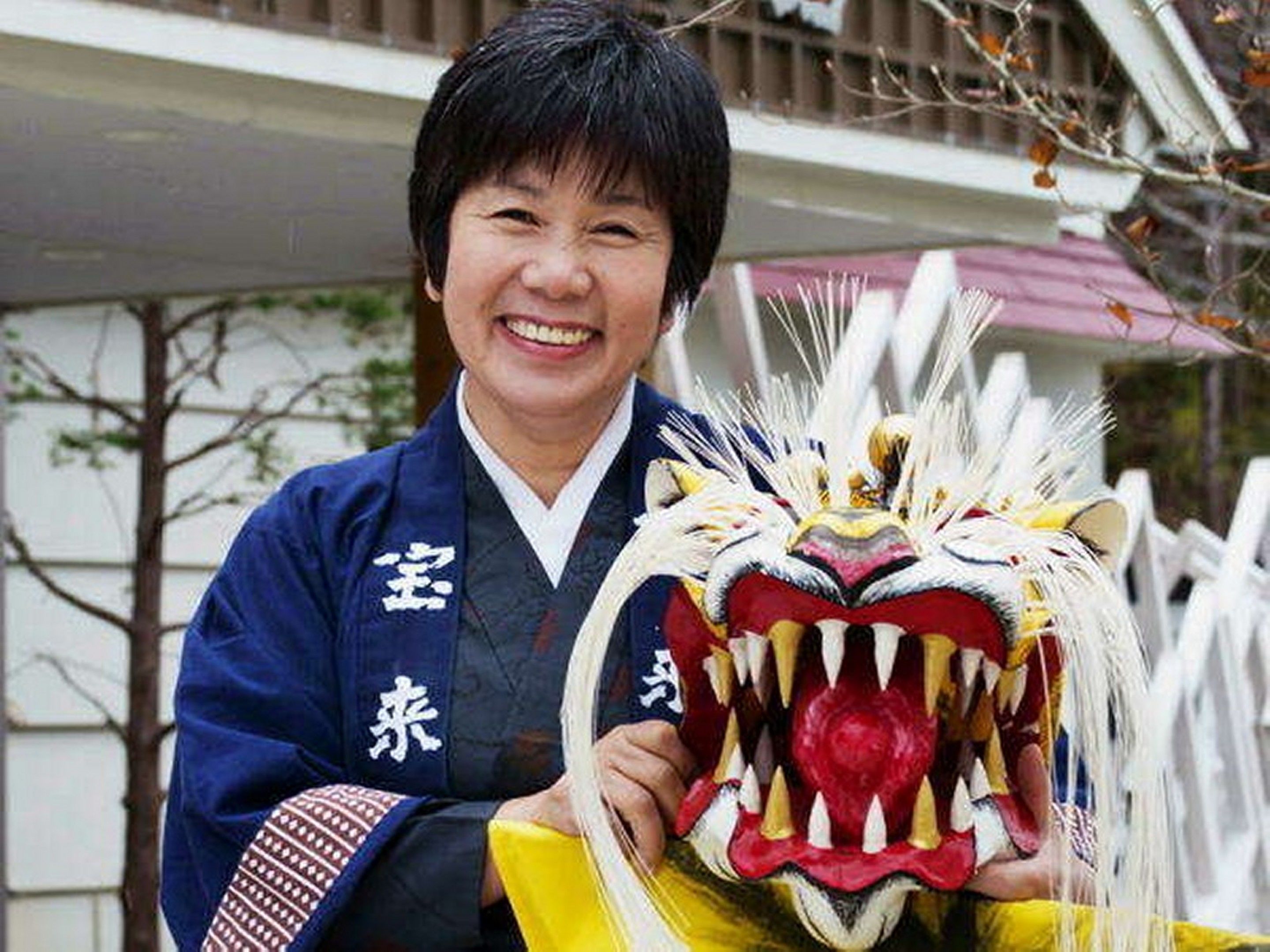 A person holding a traditional lion dance mask.