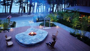 A deck with a fire pit, seating, and a view of the lake. - Hamabeno Ryouriyado Houraikan (Kamaishi)