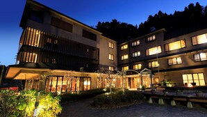 A multi-story hotel with illuminated windows and a well-lit entrance. - Hamabeno Ryouriyado Houraikan (Kamaishi)