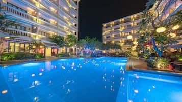 Una piscina al aire libre, sombrillas, sillones reclinables de piscina