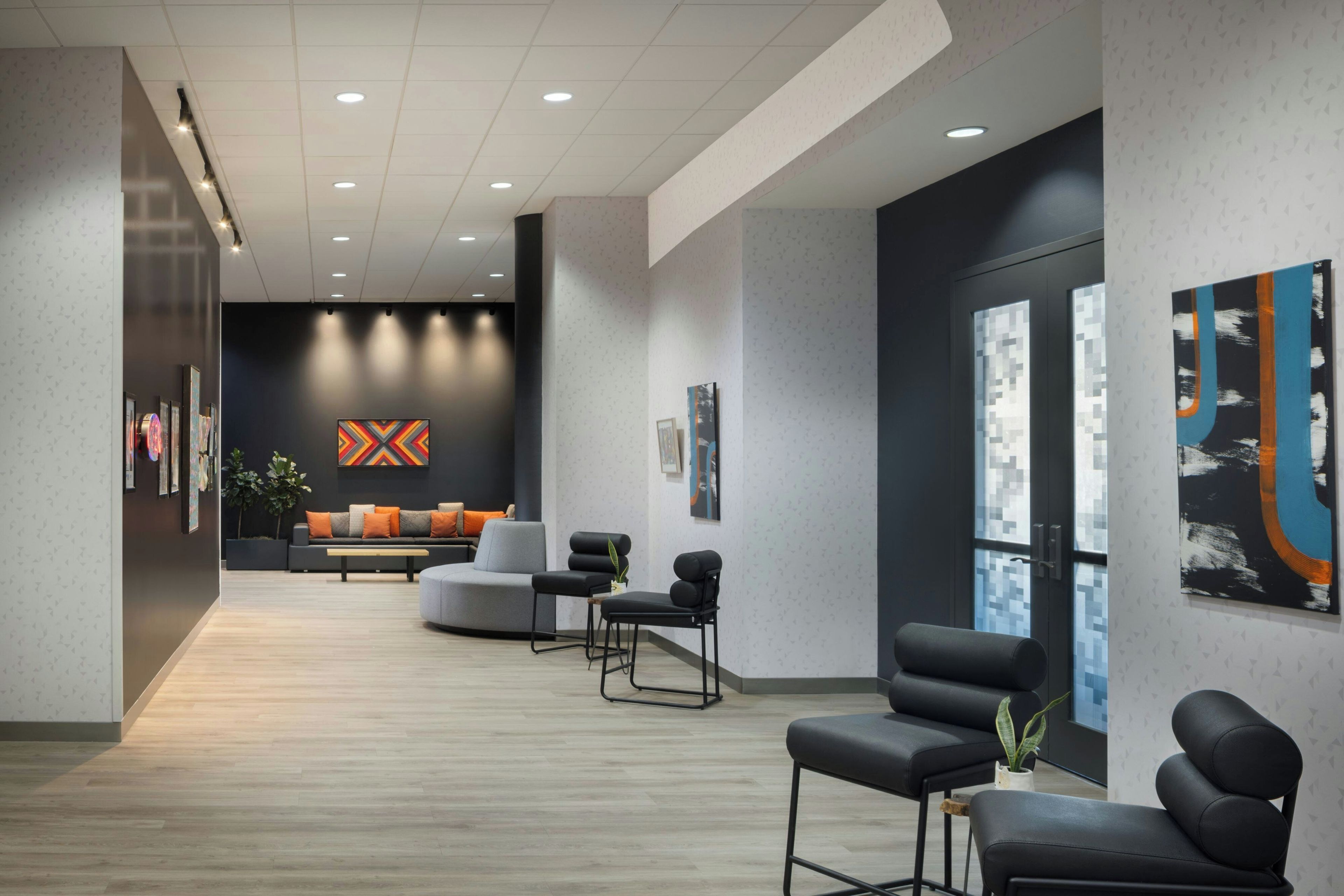 A modern waiting area with a sofa, chairs, and artwork on the walls.