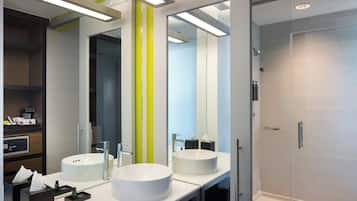 Un baño moderno con dos lavamanos, un espejo y una ducha.