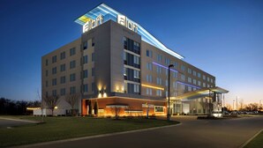 A modern hotel with a flat roof, multiple floors, and a covered entrance area. - Aloft by Marriott Wichita (Wichita)