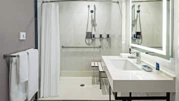 A modern bathroom with a shower, a sink, and a mirror.