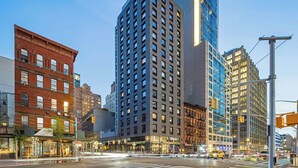 A cityscape with modern and historic buildings, a busy intersection, and clear skies.