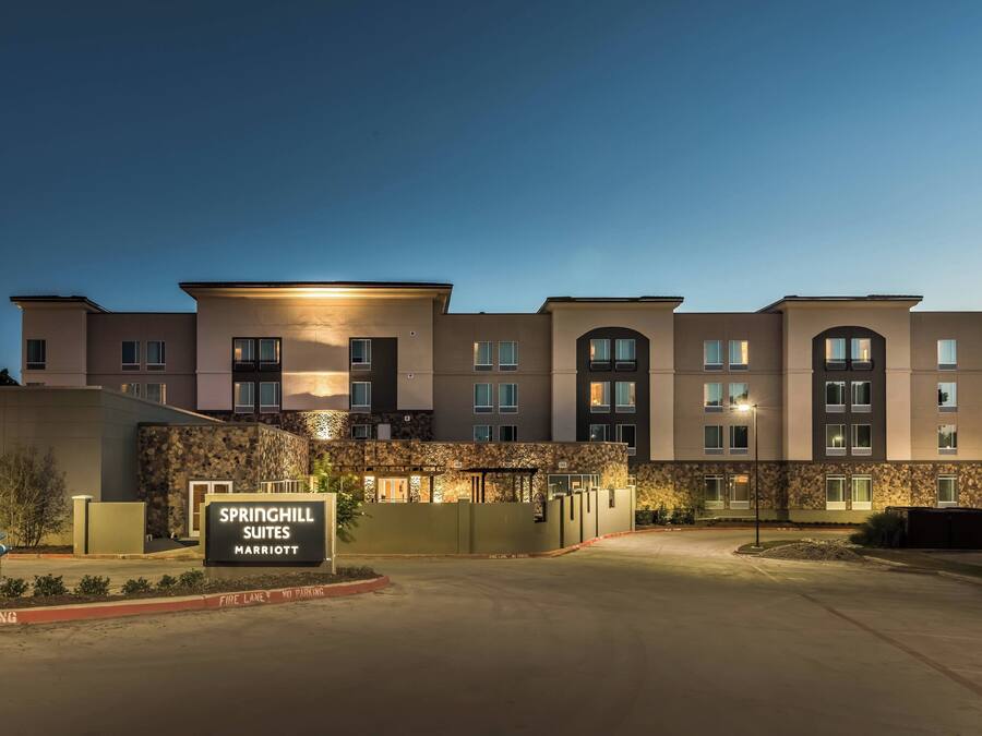 Un hotel a più piani con facciata in pietra, un cartello con su scritto "Springhill Suites Marriott" e un cordolo del piano antincendio.