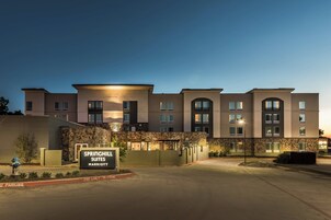 Un hotel de varios pisos con fachada de piedra, un cartel que dice "Springhill Suites Marriott" y una barrera de delimitación de carril de emergencia.