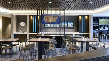 Un restaurante moderno con barra, techo de madera y un gran mapa en la pared.