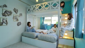 Une chambre avec un lit superposé, un coin lecture et des œuvres d’art murales.