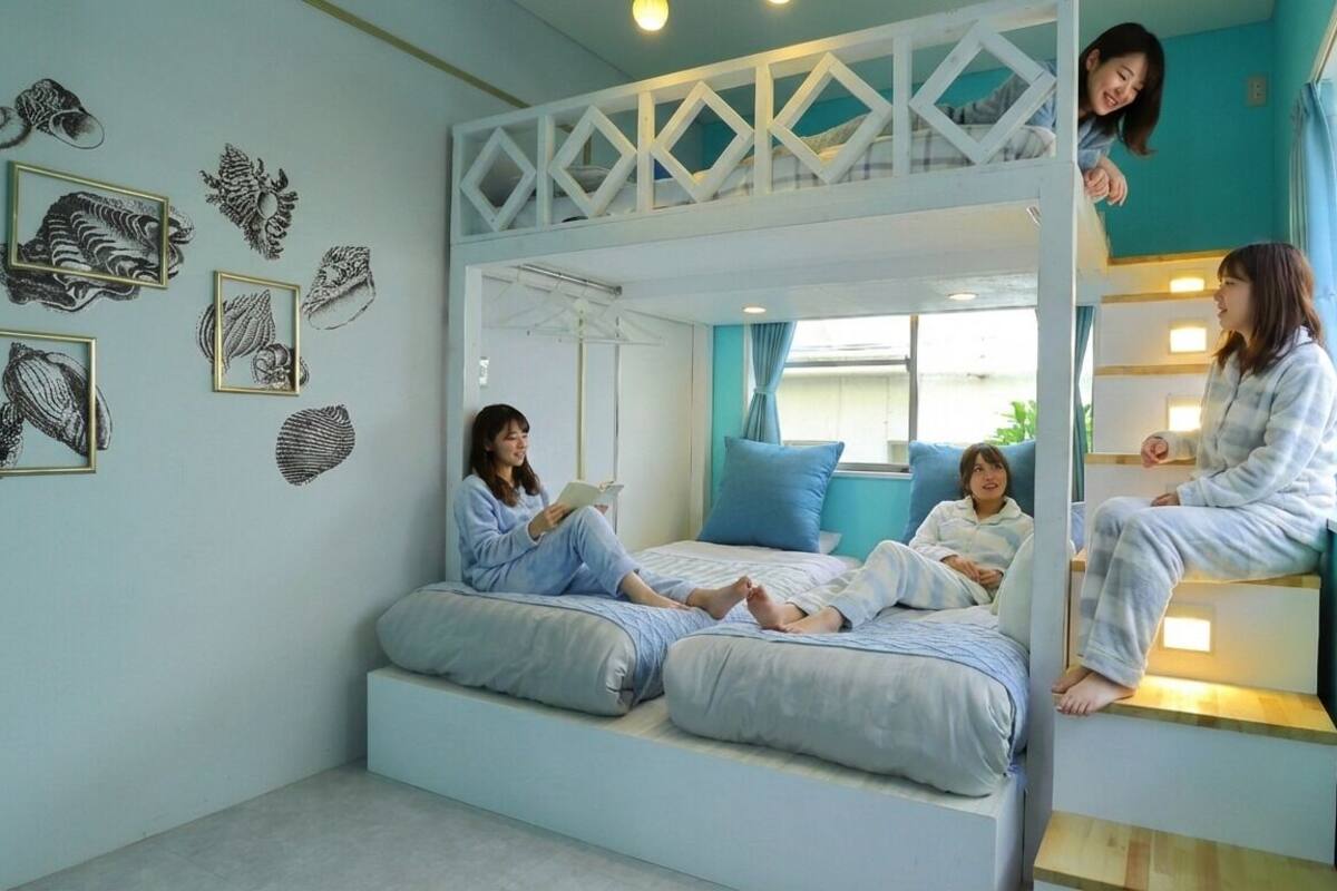 Une chambre avec un lit superposé, un coin lecture et des œuvres d’art murales.