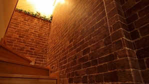 Un mur de briques avec un escalier en bois menant vers le haut.