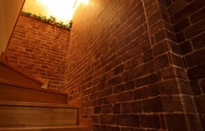 A brick wall with a wooden staircase leading upwards. - Enoshima Guest House 134 - Hostel (Fujisawa)