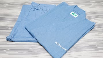 Twee blauwe handdoeken gevouwen, met een logo en tekst.