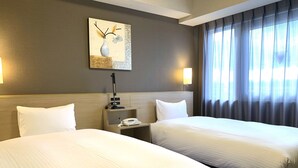 A hotel room with two beds, a nightstand with a phone, a lamp, and a painting on the wall. - Hotel Route Inn Isesaki Inter (Isesaki)