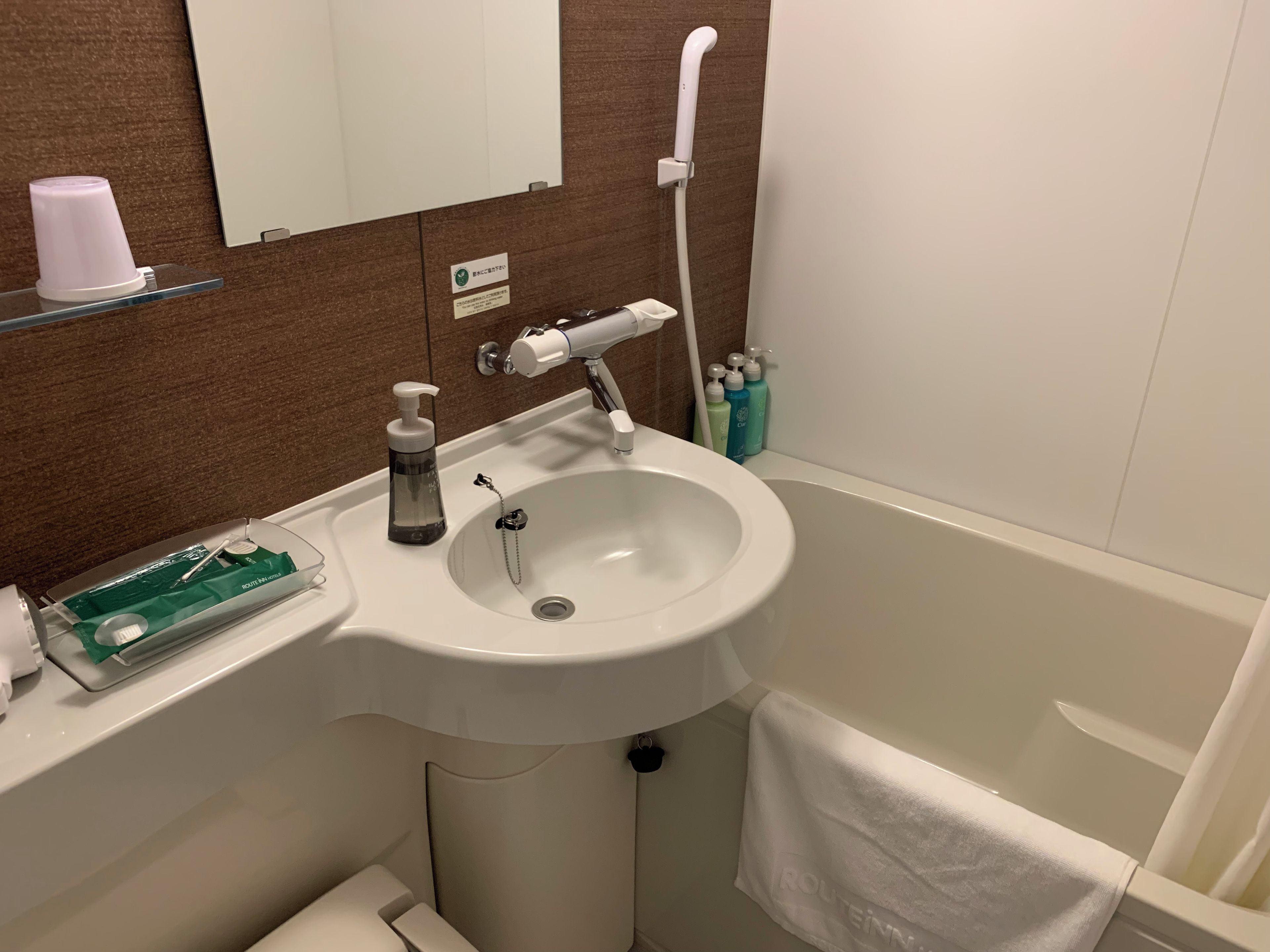 Une salle de bain avec un lavabo, un miroir et une serviette accrochée au mur.