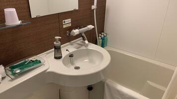 A bathroom with a sink, mirror, and a towel hanging on the wall.