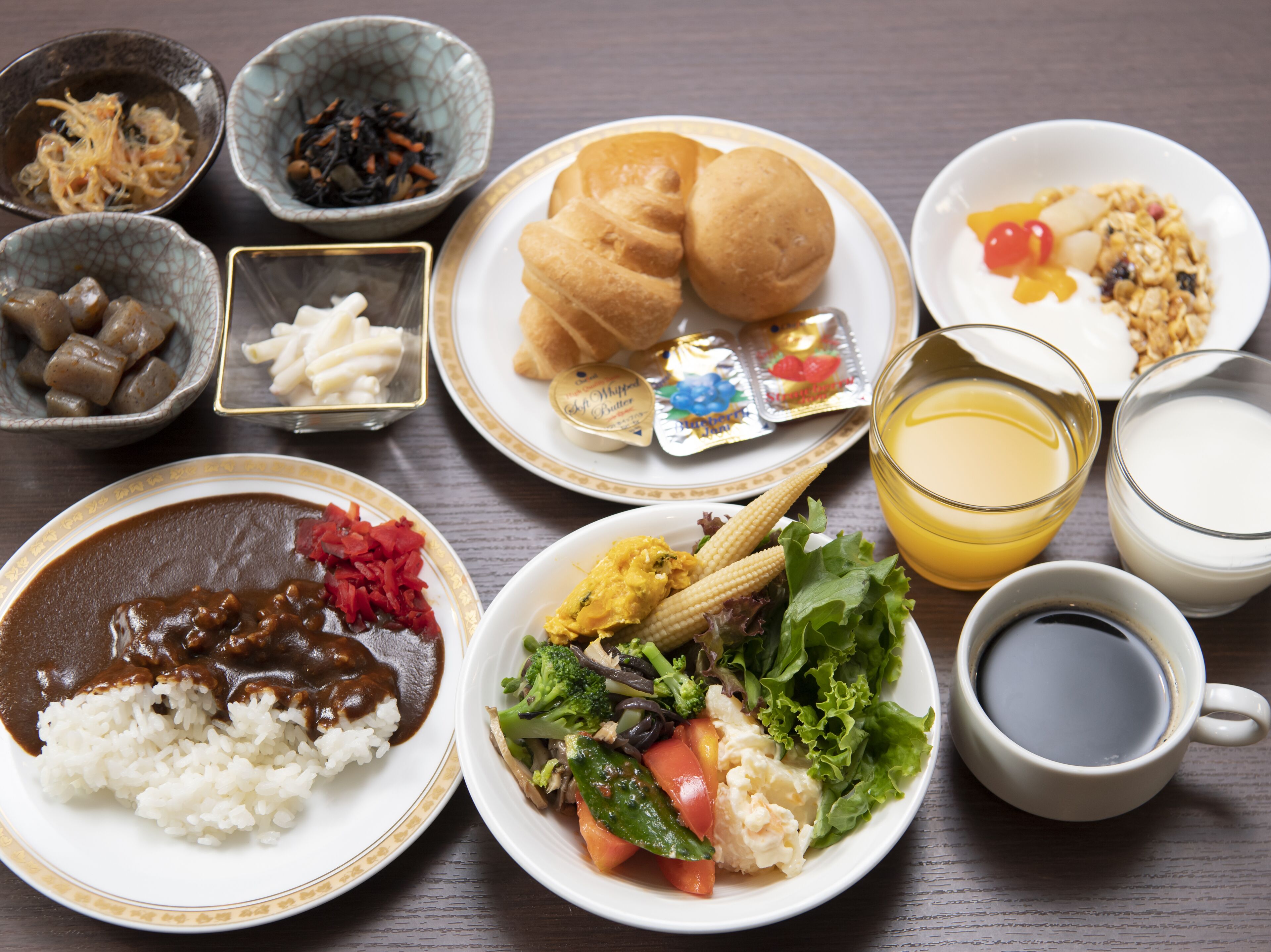 A table with various dishes including rice, salad, and bread.