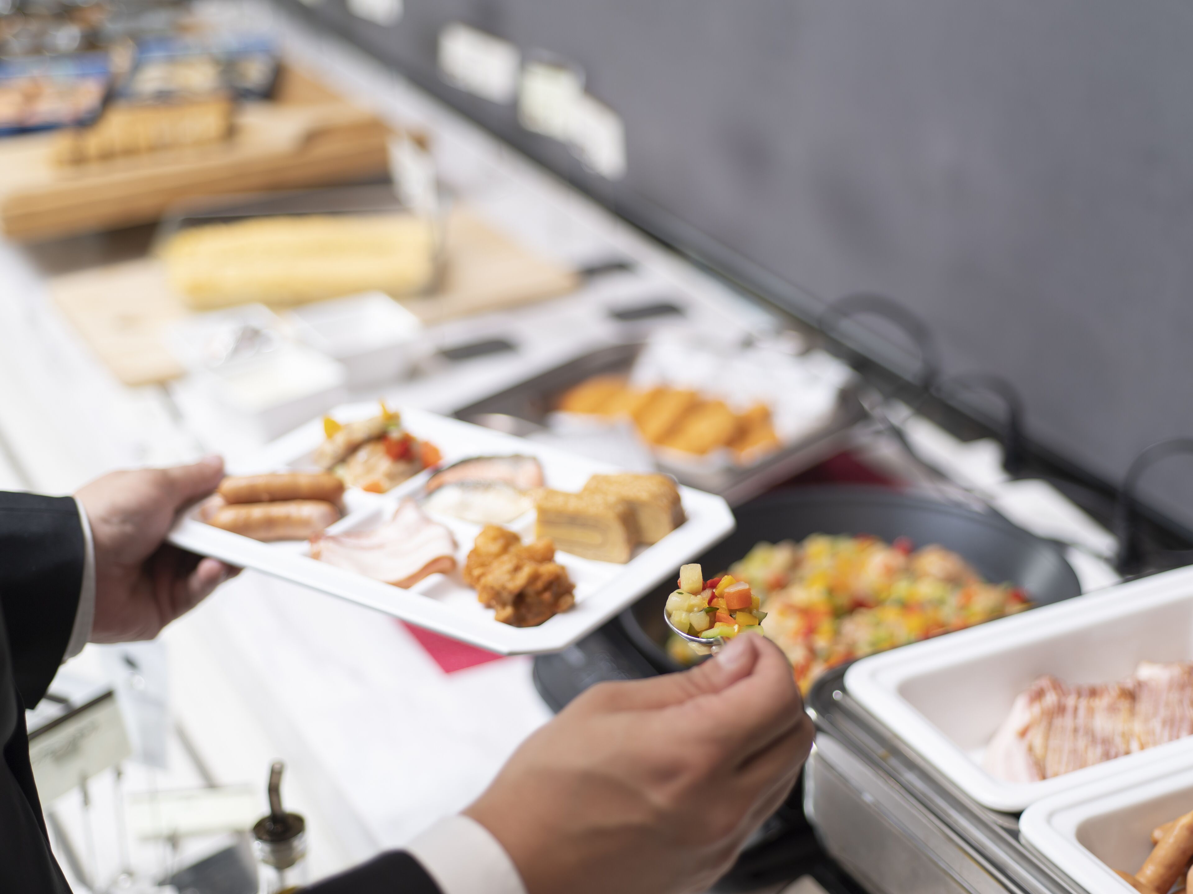 A buffet with various food items including fried chicken, waffles, and a fruit salad.
