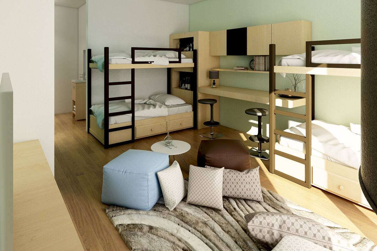 A compact room with bunk beds, a desk, and a small seating area.
