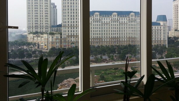 A view from a window overlooking a large building complex with multiple high-rise structures.