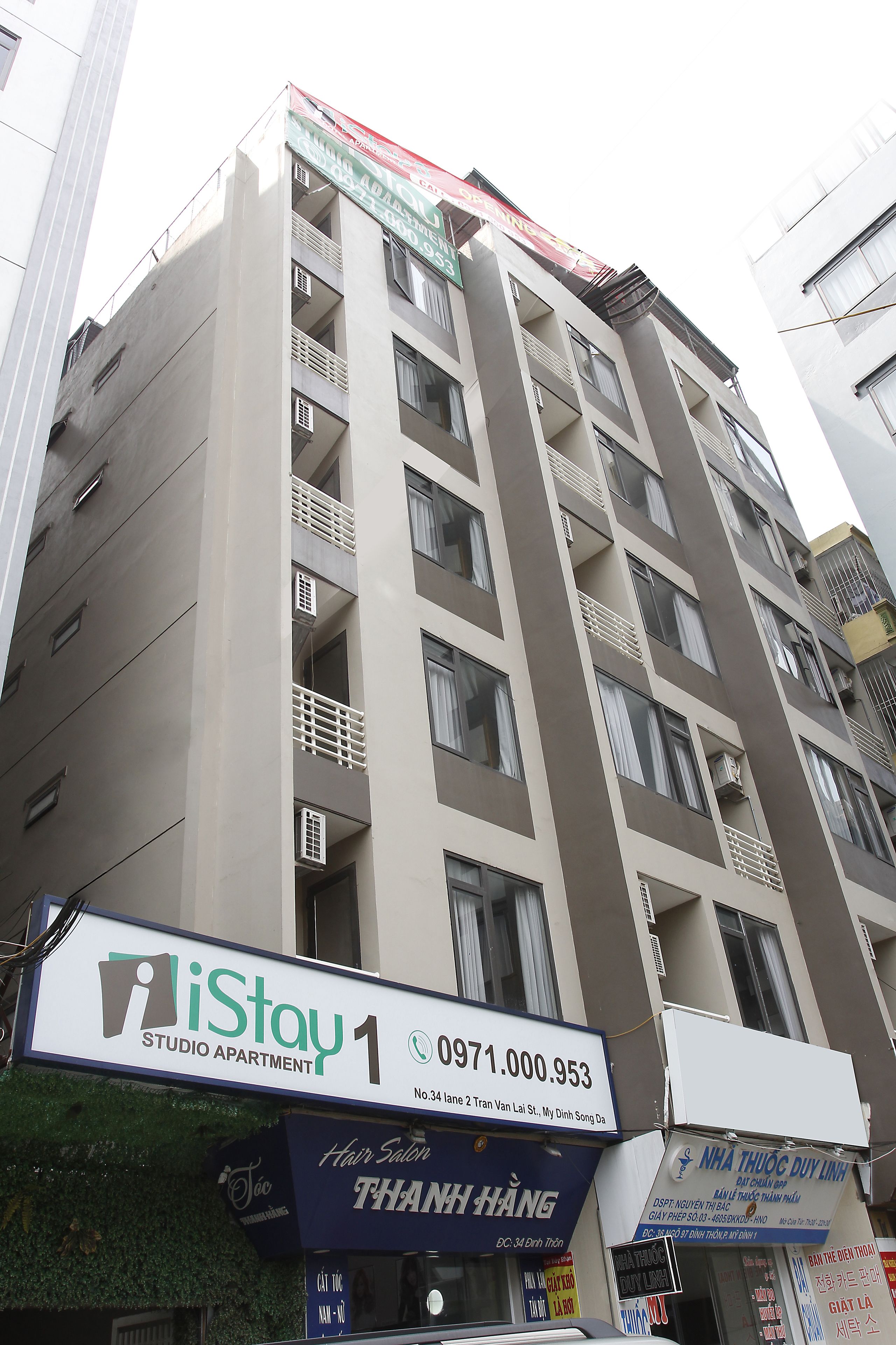 Un edificio de varios pisos con balcones y unidades de aire acondicionado.